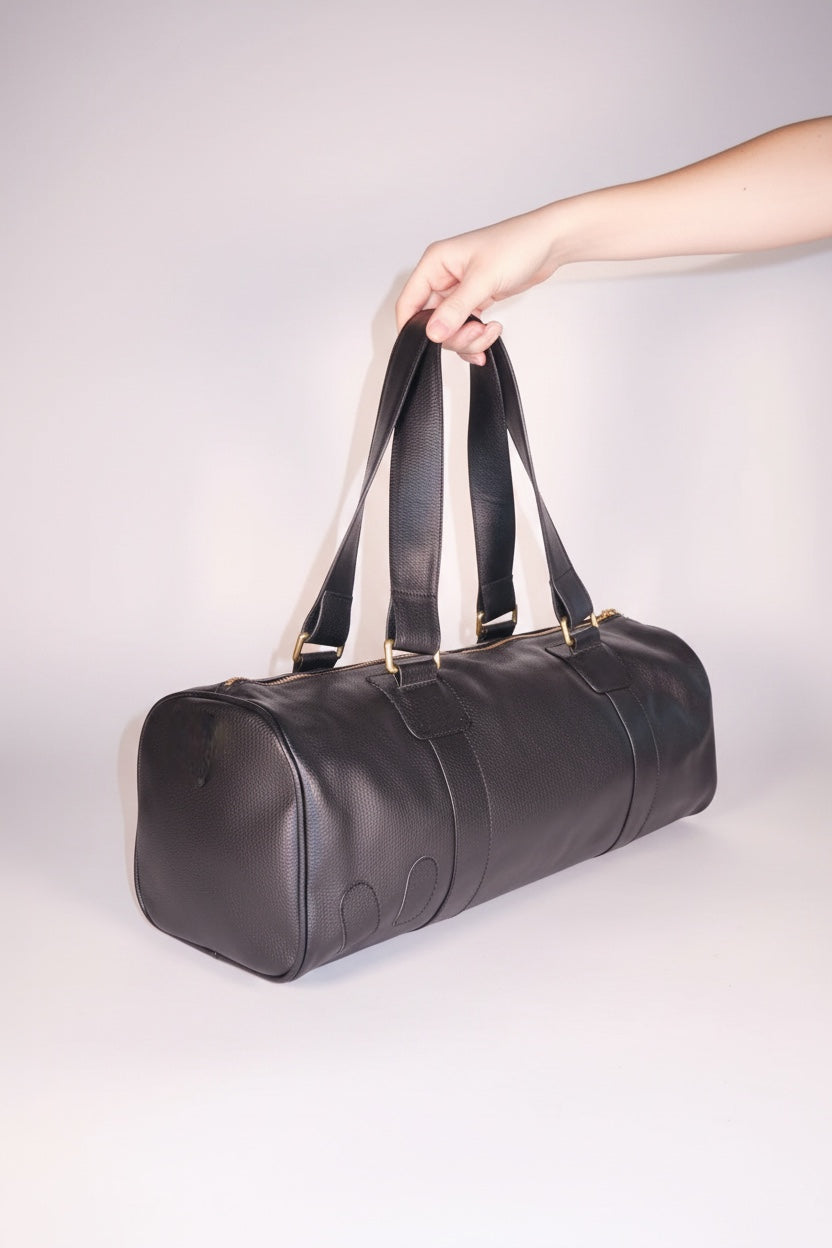 Black vegetable tanned leather mini duffle bag with cotton lining and gold hardware by design Girls World.