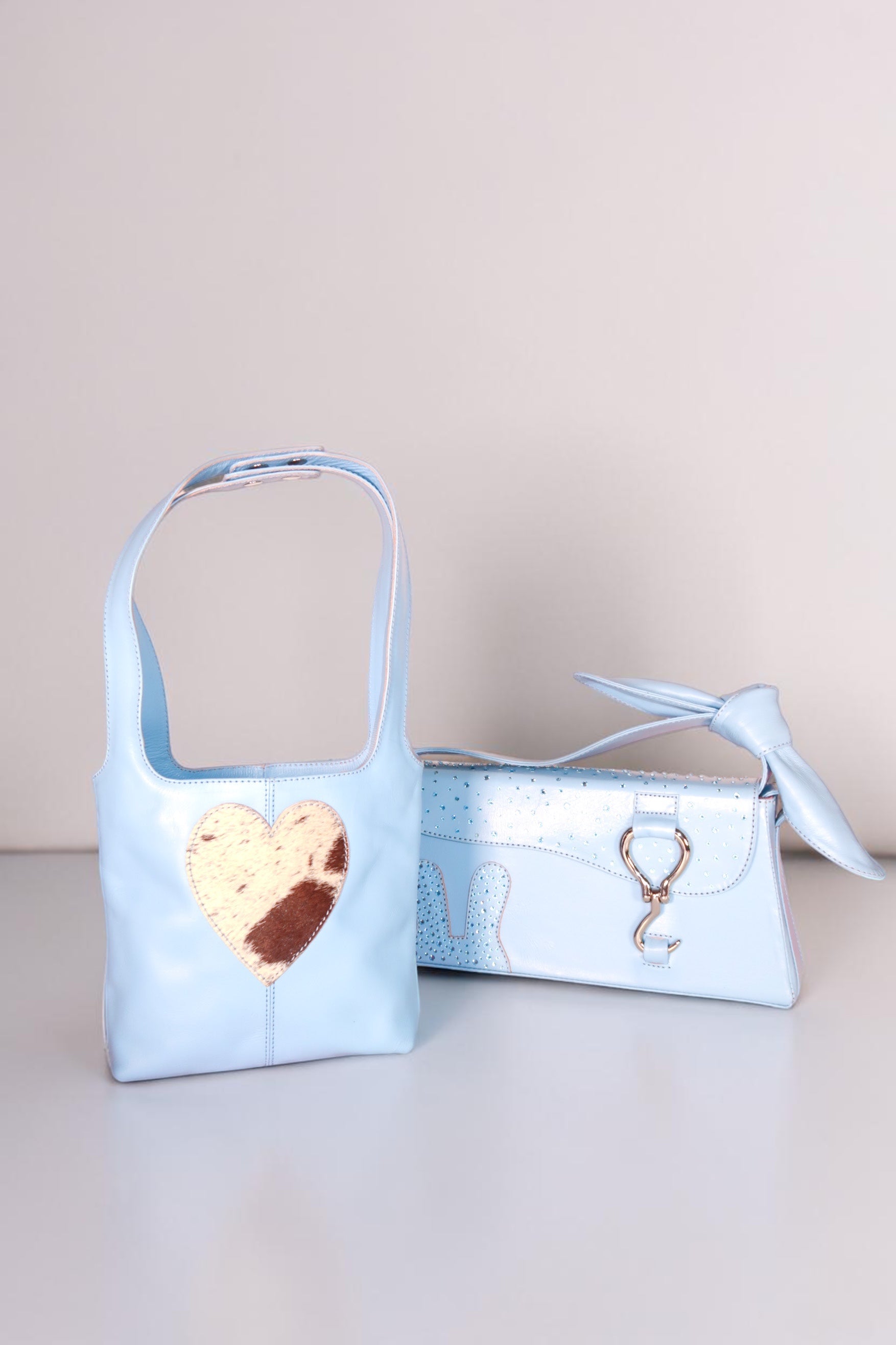 Design Girls World light blue leather mommy & me bag set with heart detail and crystal-embellished mini tote.