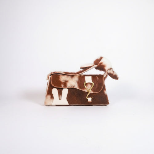 design Girls World brown and white cowhide leather mini shoulder bag with bunny ears detail and gold hardware.