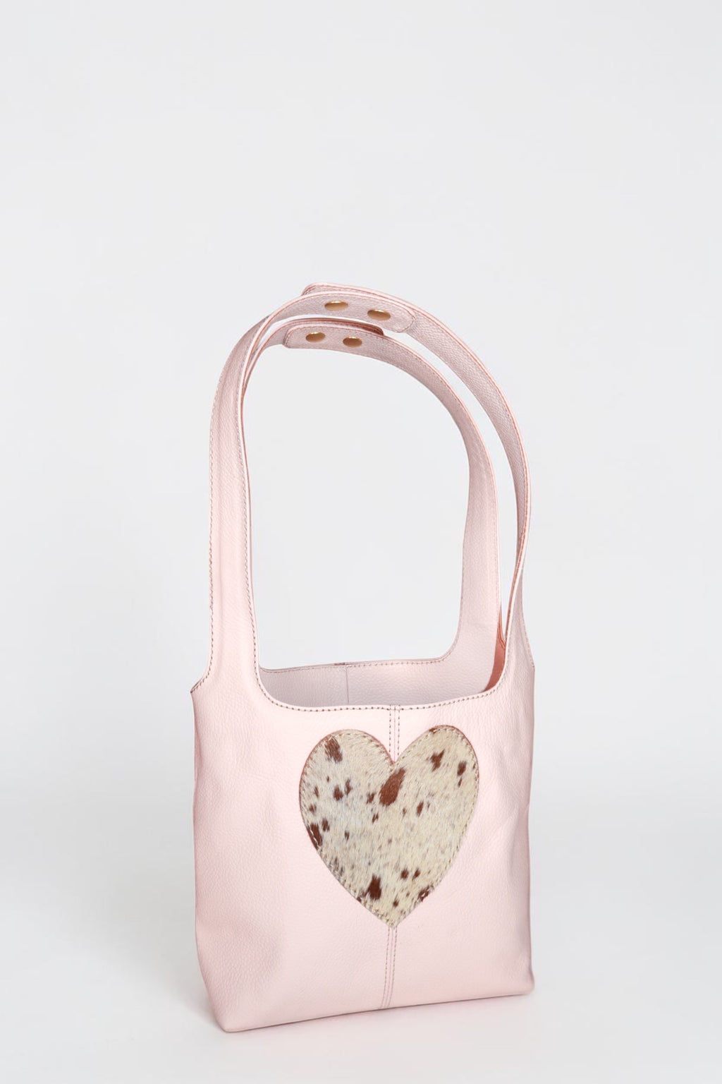 Design Girls World pink leather mini tote bag with a cowhide heart cutout detail and top handles.